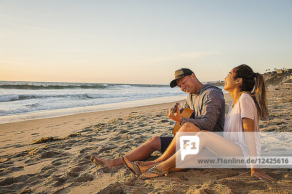 Paar sitzt am Strand