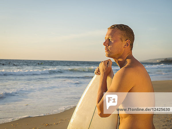 Porträt eines Mannes mit Surfbrett