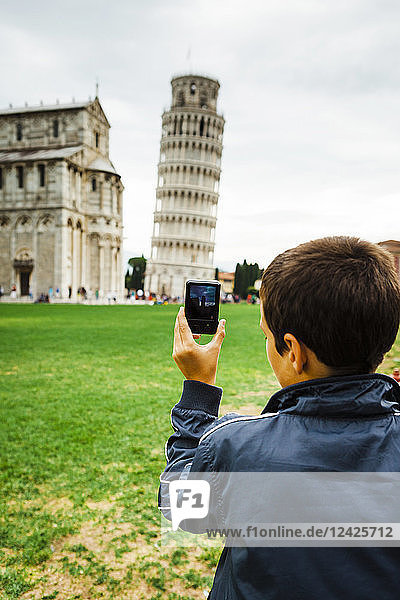 Italien  Toskana  Pisa  Rückansicht eines Teenagers (16-17)  der den Schiefen Turm von Pisa mit seinem Smartphone fotografiert
