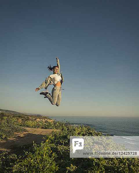 USA  California  Newport Beach  Woman jumping against clear sky
