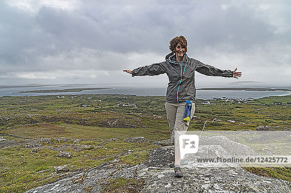 Irland  Grafschaft Galway  Frau beim Wandern über der Galway Bay