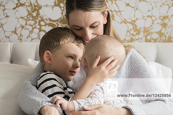 Porträt einer glücklichen Mutter mit zwei Kindern (18-23 Monate  4-5)