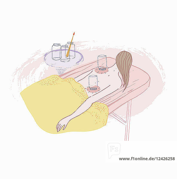 Frau auf dem Bauch liegend mit Schröpftherapie
