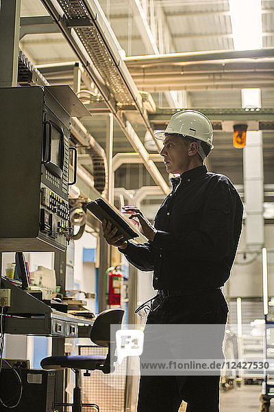 Factory worker using digital tablet in factory