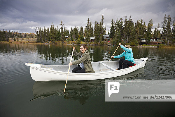Two women canoeing on Lac Le Jeune  Kamloops  British Columbia  Canada