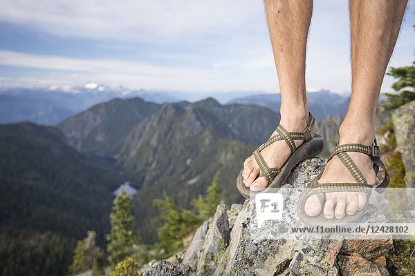 Füße eines Wanderers in Sandalen  der in den Bergen steht  Vancouver  British Columbia  Kanada