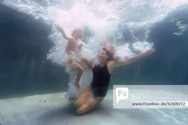 Underwater view of mother and son swimming in swimming pool