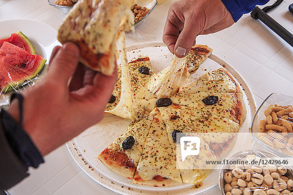 Close-up of people eating pizza