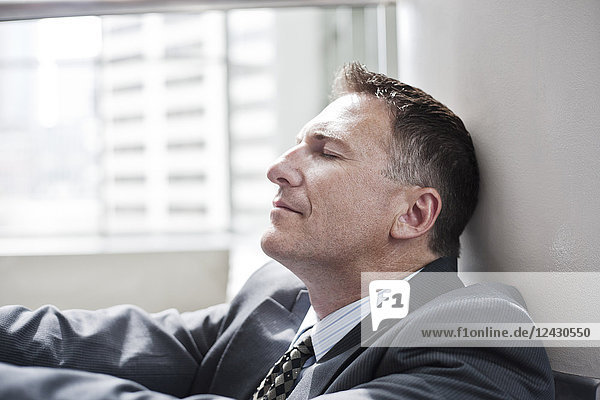 Closeup side view of a Caucasian businessman with his eyes closed..