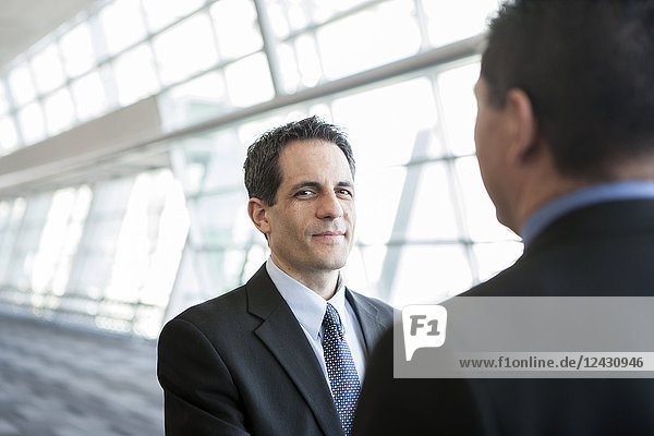 Businessman looking at the camera during discussion in a conference centre lobby.