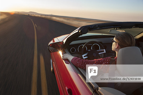 Ein Blick von oben auf eine kaukasische Frau  die einen Cabrio-Sportwagen fährt.