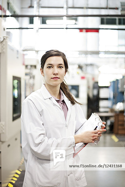 A portrait of a Caucasian female technician in a technical research and development site.