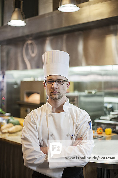 Ein Porträt eines kaukasischen männlichen Kochs in einer Großküche.