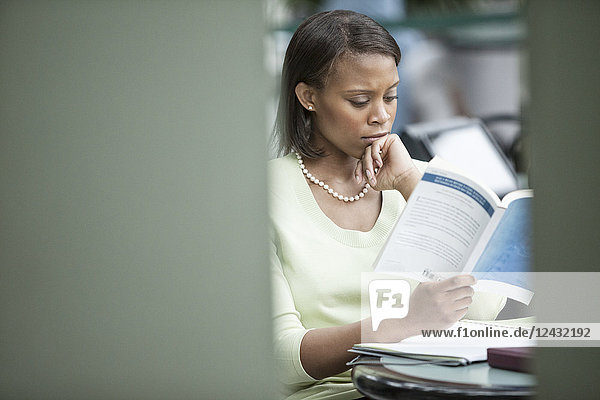 A black businesswoman reading a report.