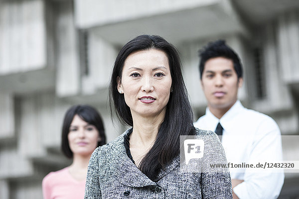 Ein gemischtrassiges Team von Geschäftsleuten mit einer asiatischen Geschäftsfrau an der Spitze.
