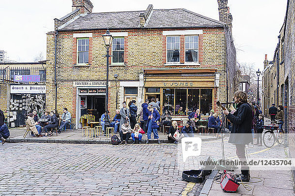 Busker entertains in Columbia Road area  a very popular Sunday market between Hoxton and Bethnal Green in East London  London  England  United Kingdom  Europe