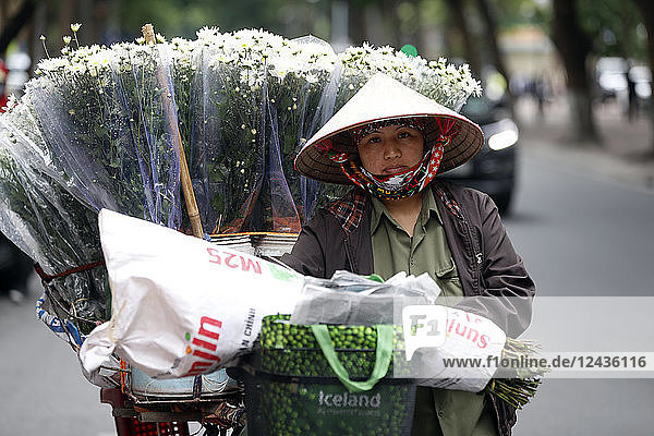 Verkäuferin verkauft Blumen von ihrem mobilen Fahrradladen aus  Hanoi  Vietnam  Indochina  Südostasien  Asien