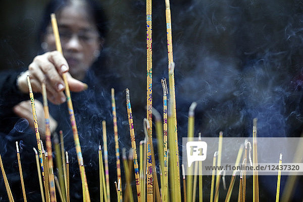 Mariamman Hindu Temple  woman burning incense sticks  Ho Chi Minh City. Vietnam  Indochina  Southeast Asia  Asia