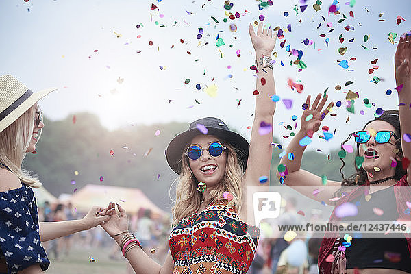 Friends dancing among confetti at the music festival