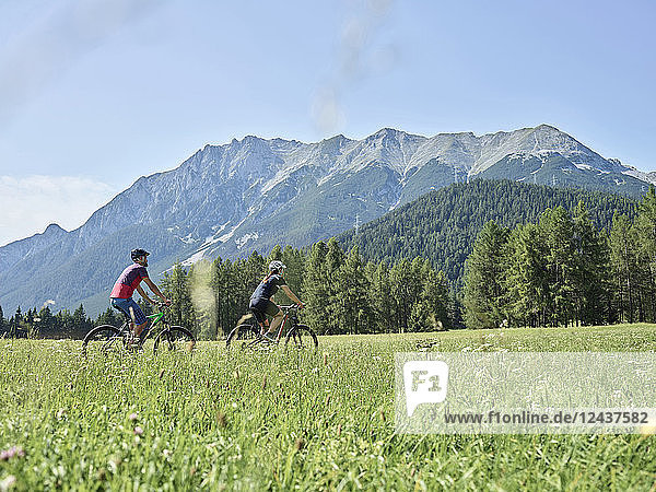 Austria  Tyrol  Mieming  couple riding bike in alpine scenery