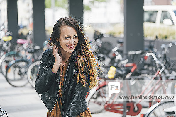 Portrait of happy young woman at bicycle parking station in the city