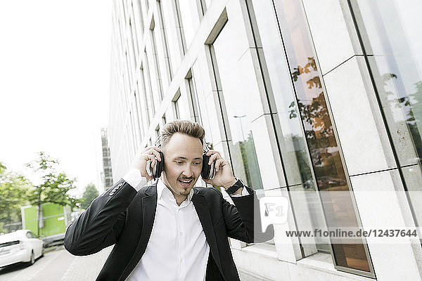Young businessman wearing headphones in the city