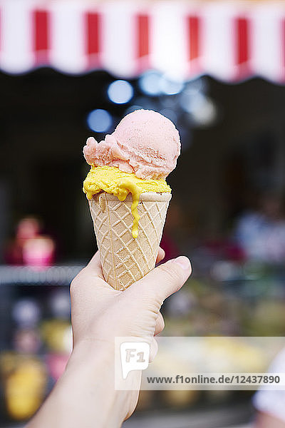 Woman's hand holding ice cream cone with two scoops