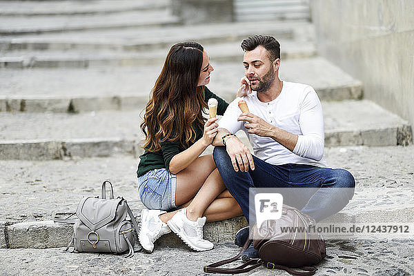 Tourist couple eating ice cream cones in the city