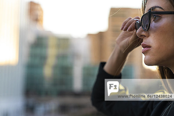 Portrait of attractive young woman wearing sunglasses in the city