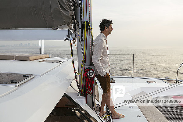 Marure man on catamaran  looking ta view
