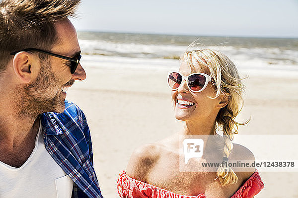 Happy couple wearing sunglasses on the beach