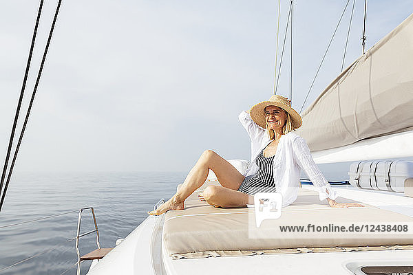Mature woman relaxing on a catamaran,  taking a sunbath