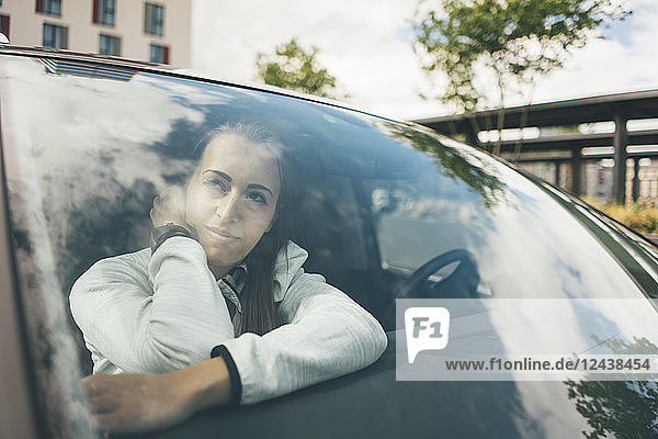 Sportive young woman in car looking out of window