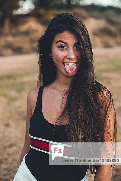 Portrait of teenage girl sticking out tongue