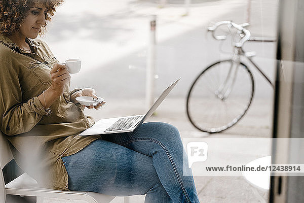 Woman working in a cafe  drinking coffee  using laptop