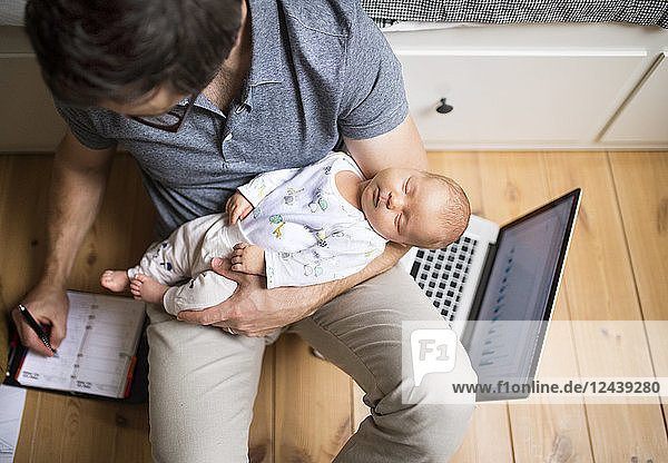 Father with his baby daughter working from home