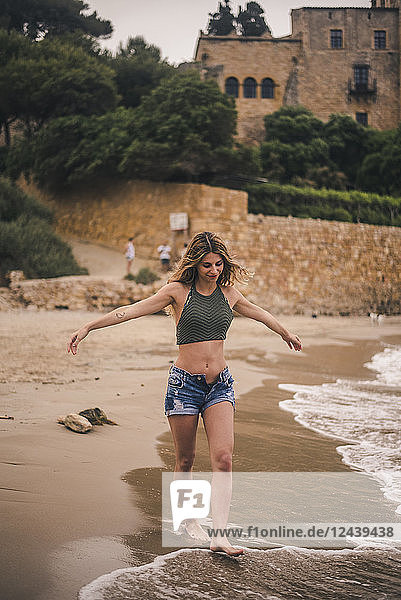 Beautiful young woman walking on the beach