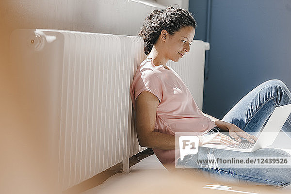 Woman sitting on ground  using laptop
