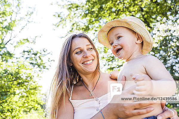 Portrait of happy woman and baby boy in nature