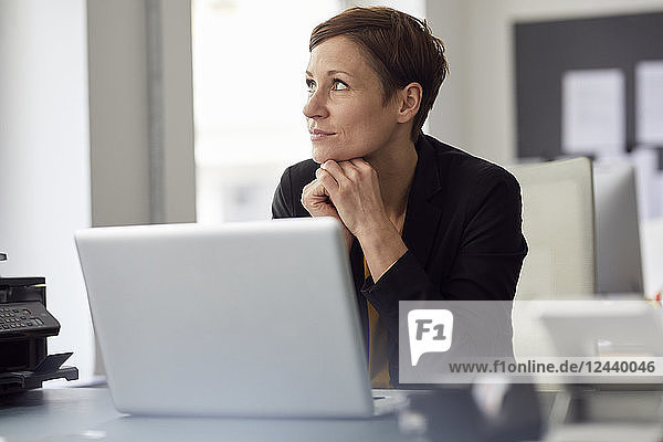 Businesswoman sitting in office  using laptop
