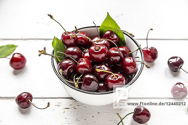 Bowl of cherries on white wood