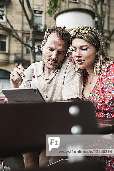 Couple looking at tablet at an outdoor cafe