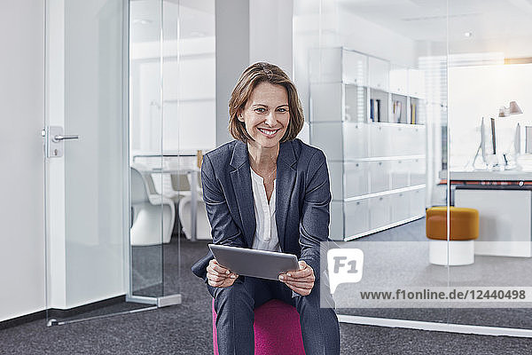 Portrait of smiling businesswoman using tablet in office