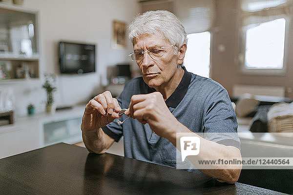 Senior man examining hearing aid