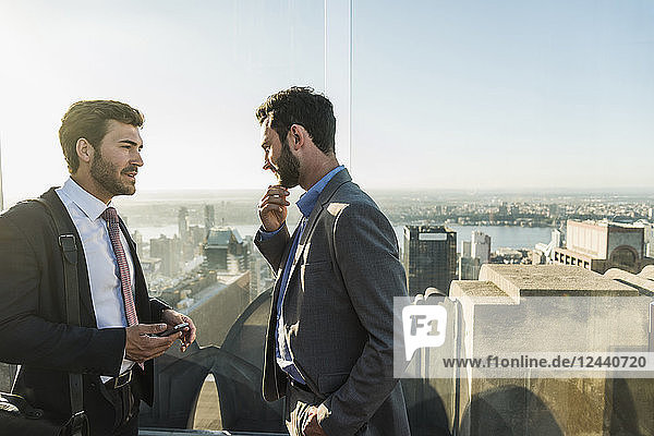 USA  New York City  two businessmen talking on Rockefeller Center observation deck