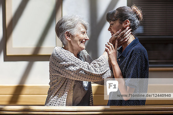 Nurse embracing senior woman in retirement home