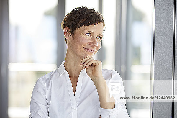 Portrait of smiling businesswoman in office looking sideways