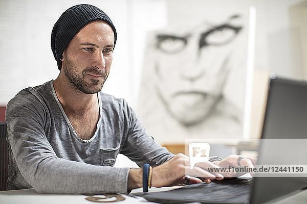 Artist using laptop in studio