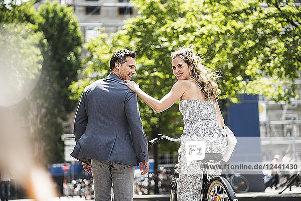 Happy couple with bicycle in the city