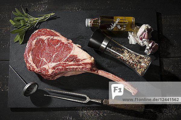 Raw tomahawk steak and ingredients